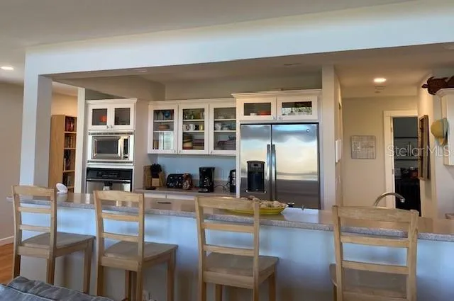 a kitchen with stainless steel appliances granite countertop a refrigerator and cabinets