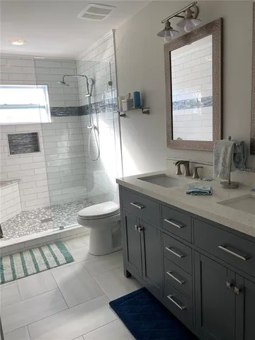 a bathroom with a double vanity sink toilet and a mirror