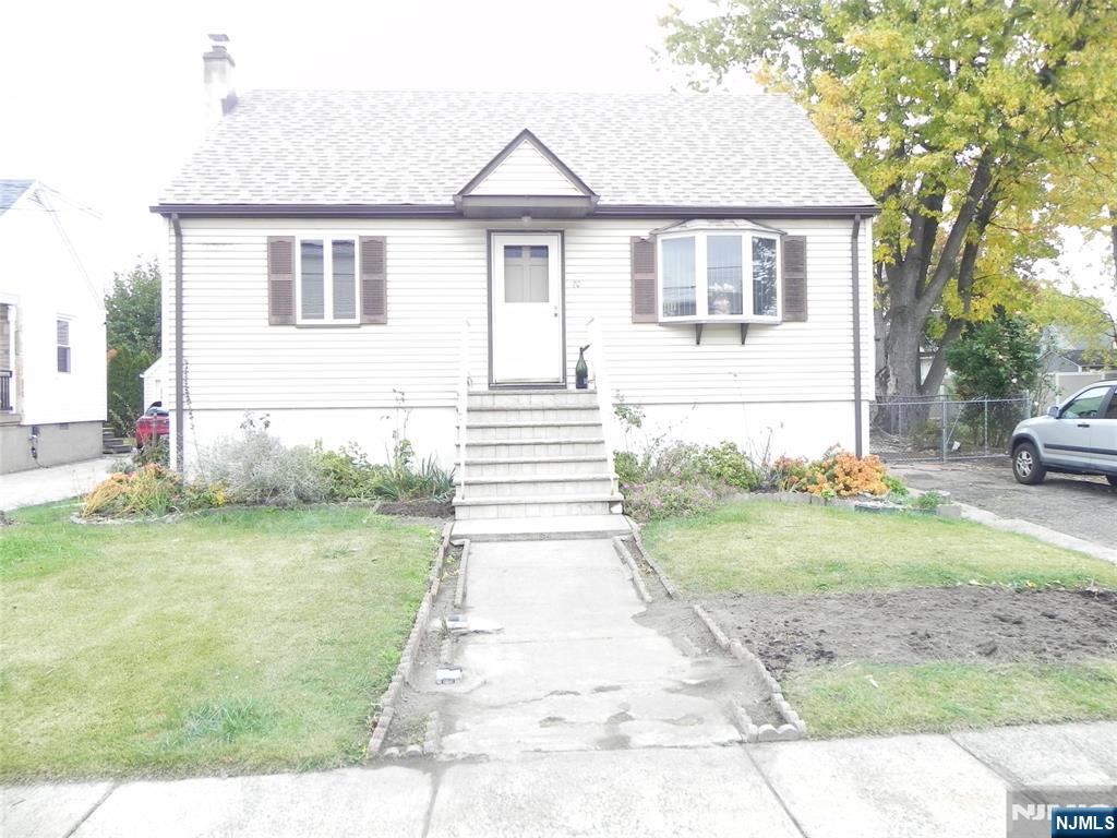 70 Christina Street Little Ferry, NJ 07643 - Photo 1 of 16 a front view of a house with a yard and garage
