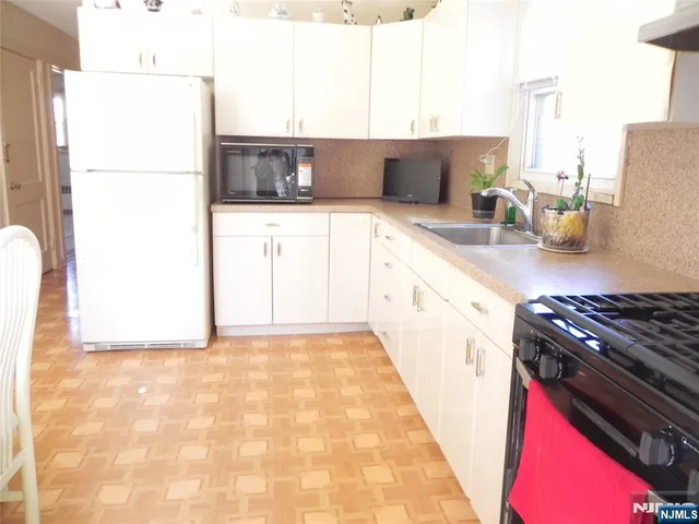 a kitchen with a sink a stove and a microwave