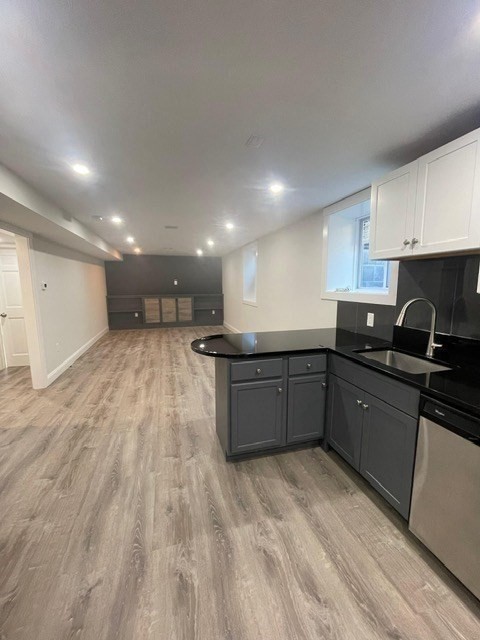a kitchen with a sink wooden cabinets and black appliances
