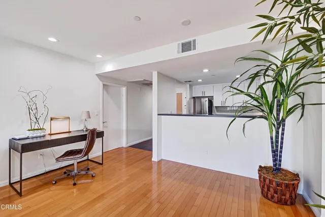 a view of a room with gym equipment and wooden floor