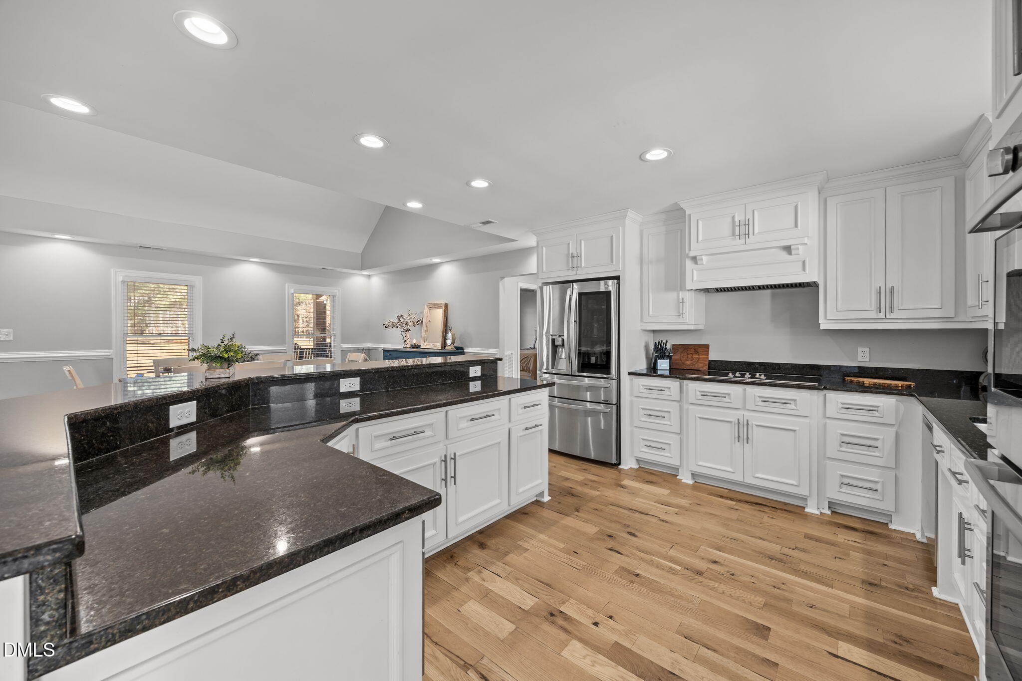 2079 Sheriff Johnson Road Lillington, NC 27546 - Photo 12 of 43 a large kitchen with stainless steel appliances granite countertop a stove a sink a refrigerator and white cabinets with wooden floor
