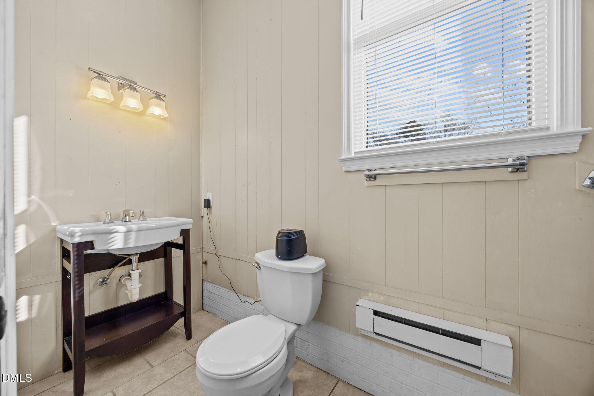 2079 Sheriff Johnson Road Lillington, NC 27546 - Photo 34 of 43 a bathroom with a toilet a sink a mirror and a window