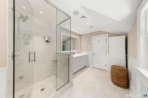 a bathroom with a tub shower and mirror