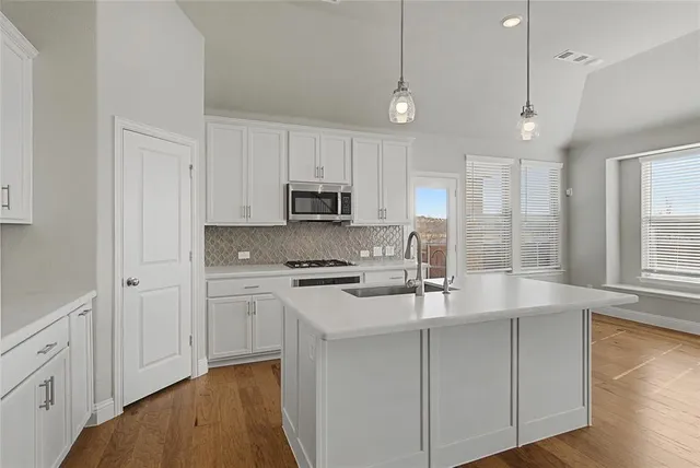 a kitchen with kitchen island granite countertop white cabinets and white appliances