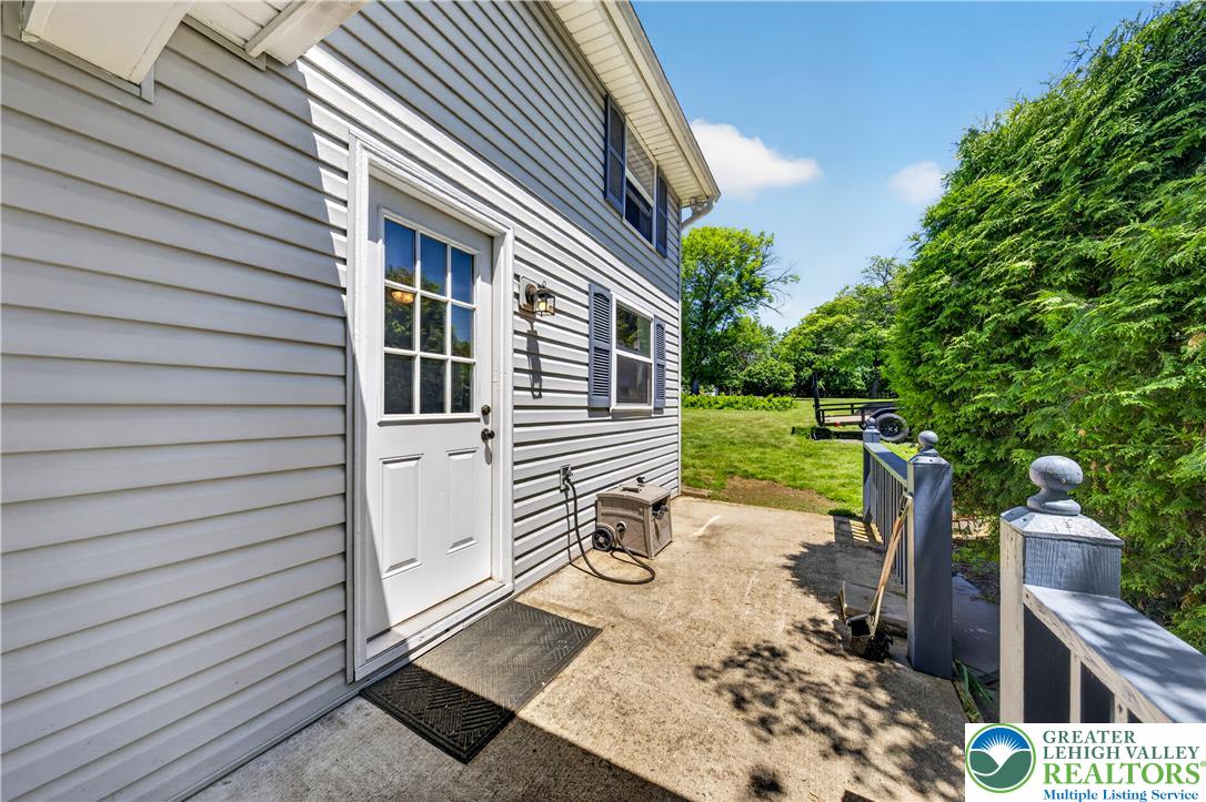 1411 Lieb Road Easton, PA 18040 - Photo 13 of 46 A quaint side entrance leads to a verdant yard, offering privacy and natural beauty.