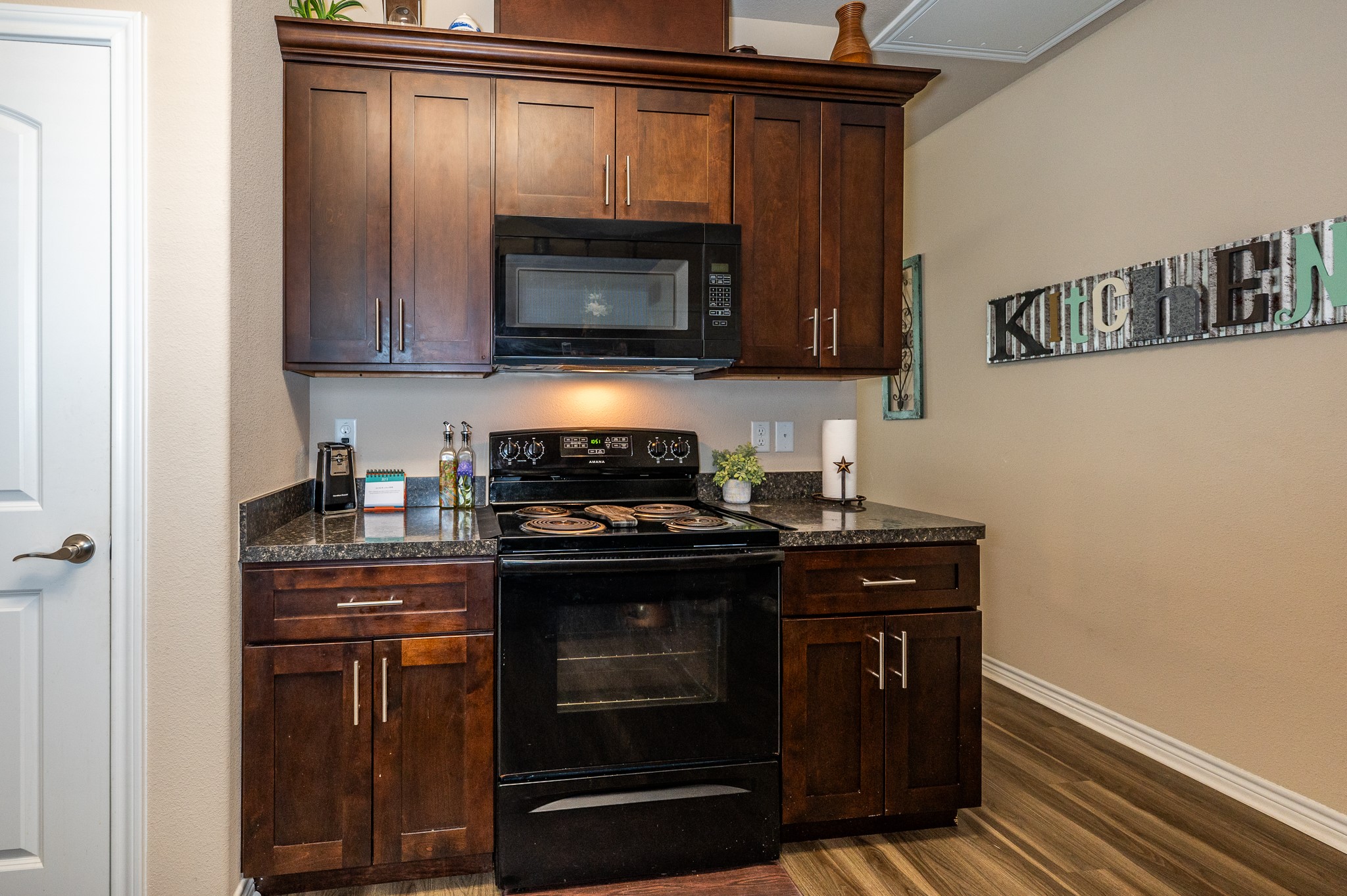 172 Curlew Street Sargent, TX 77414 - Photo 8 of 24 a kitchen with wooden cabinets and a stove top oven