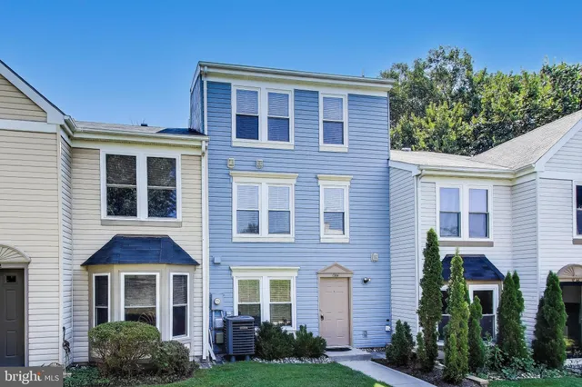 a front view of a house with a yard and potted plants
