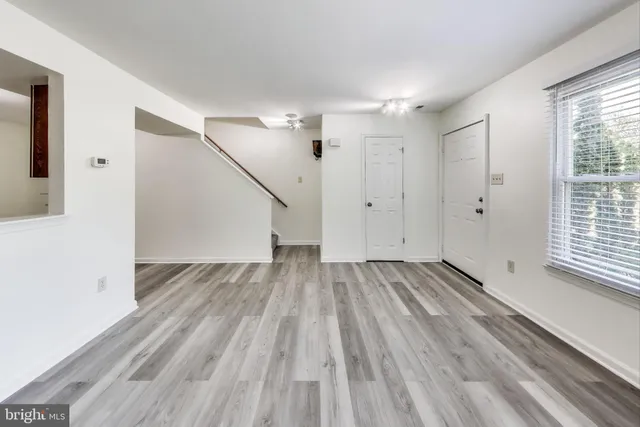 a view of a room with wooden floor and white walls