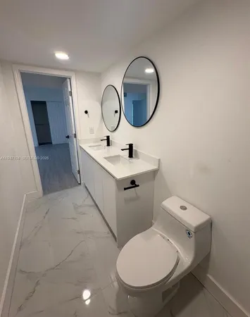 a bathroom with a toilet a sink and a mirror