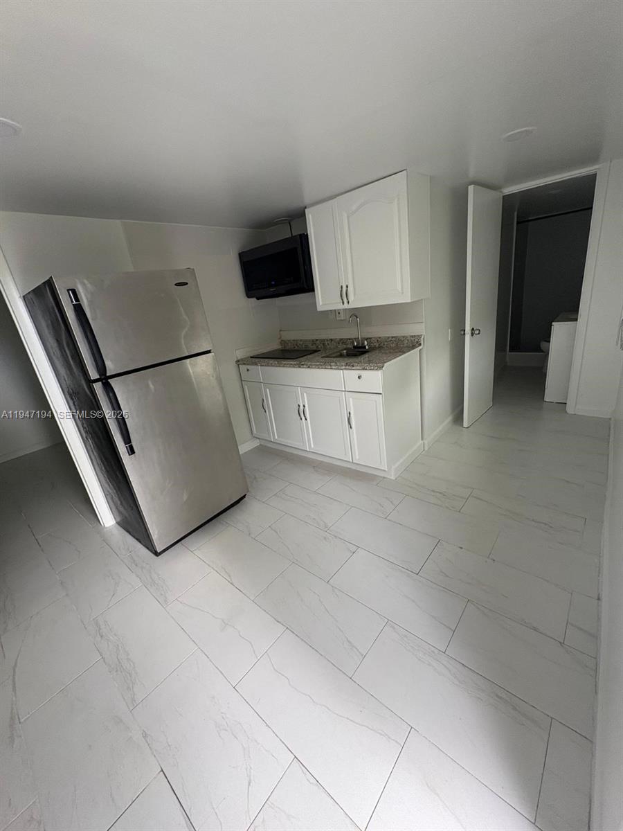 6104 Southwest 33rd Street Miramar, FL 33023 - Photo 26 of 31 a kitchen with cabinets and a stove top oven