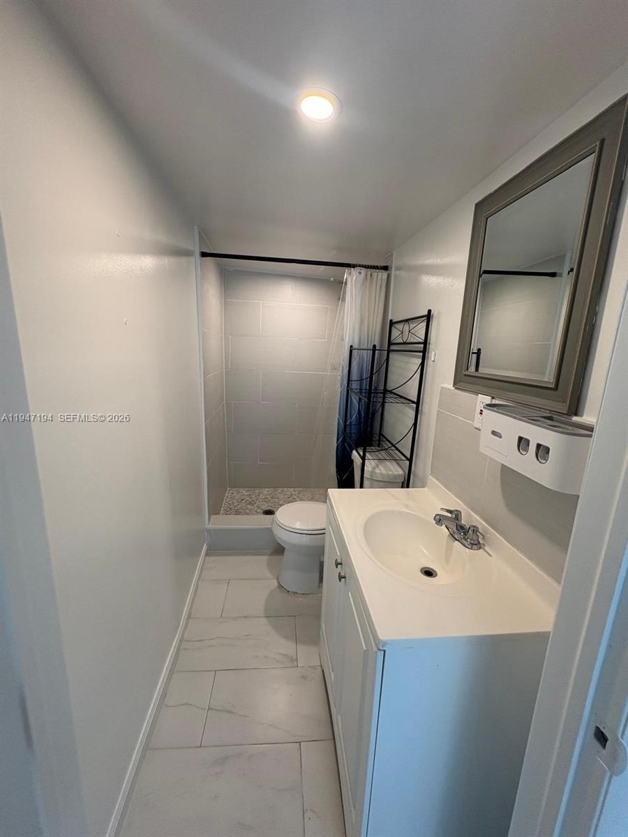 6104 Southwest 33rd Street Miramar, FL 33023 - Photo 27 of 31 a bathroom with a sink a toilet and mirror