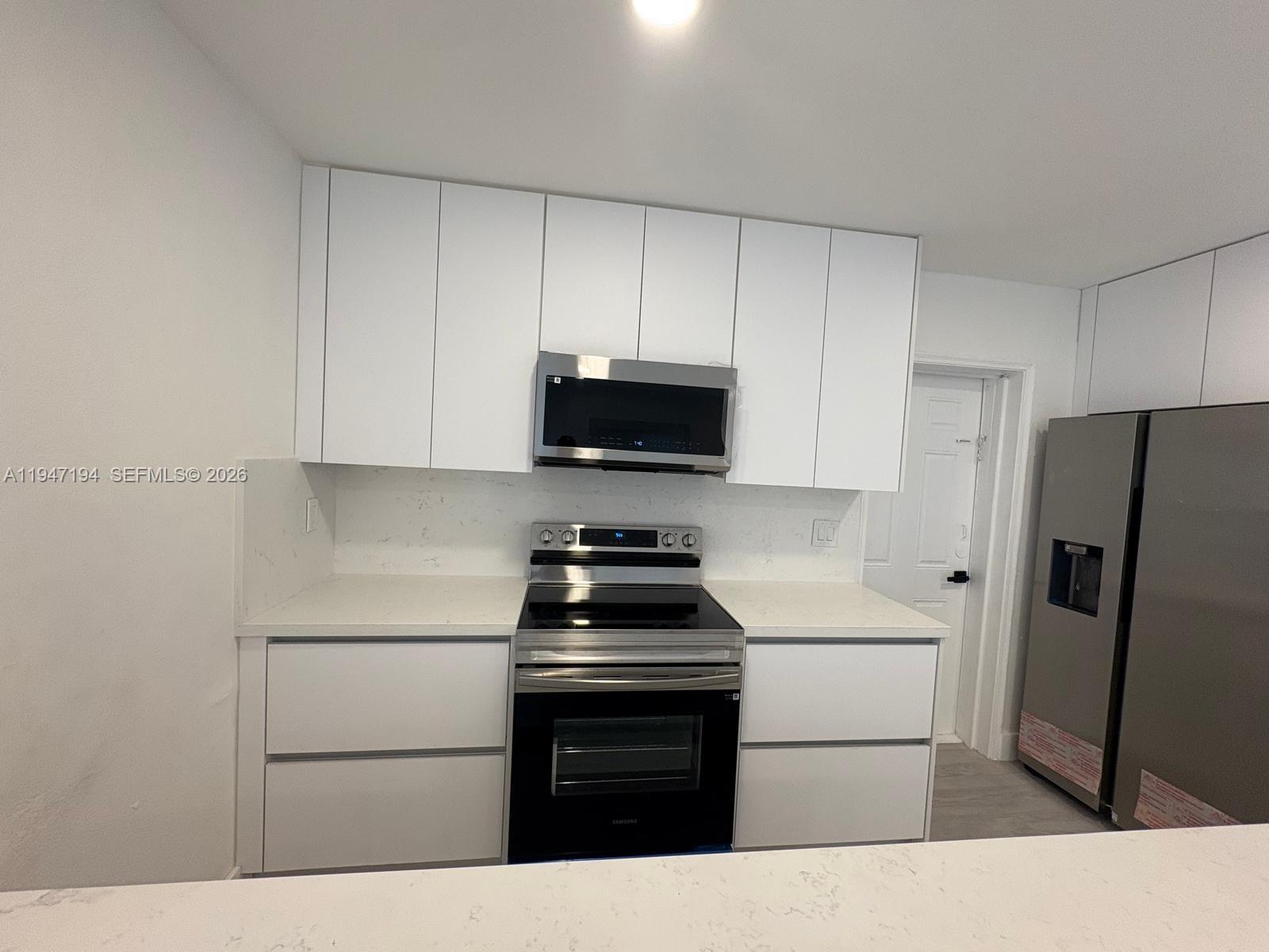 6104 Southwest 33rd Street Miramar, FL 33023 - Photo 28 of 31 a kitchen with a refrigerator stove and microwave