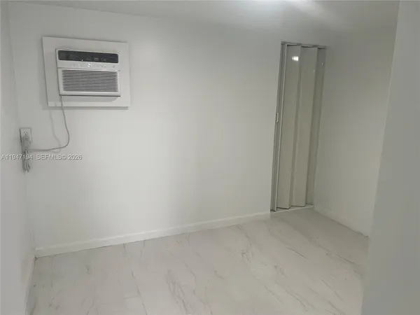 a kitchen with white cabinets and refrigerator