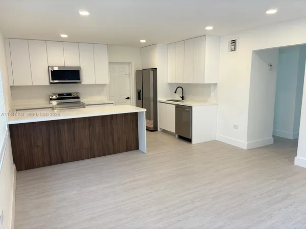 a kitchen with stainless steel appliances a sink stove and refrigerator