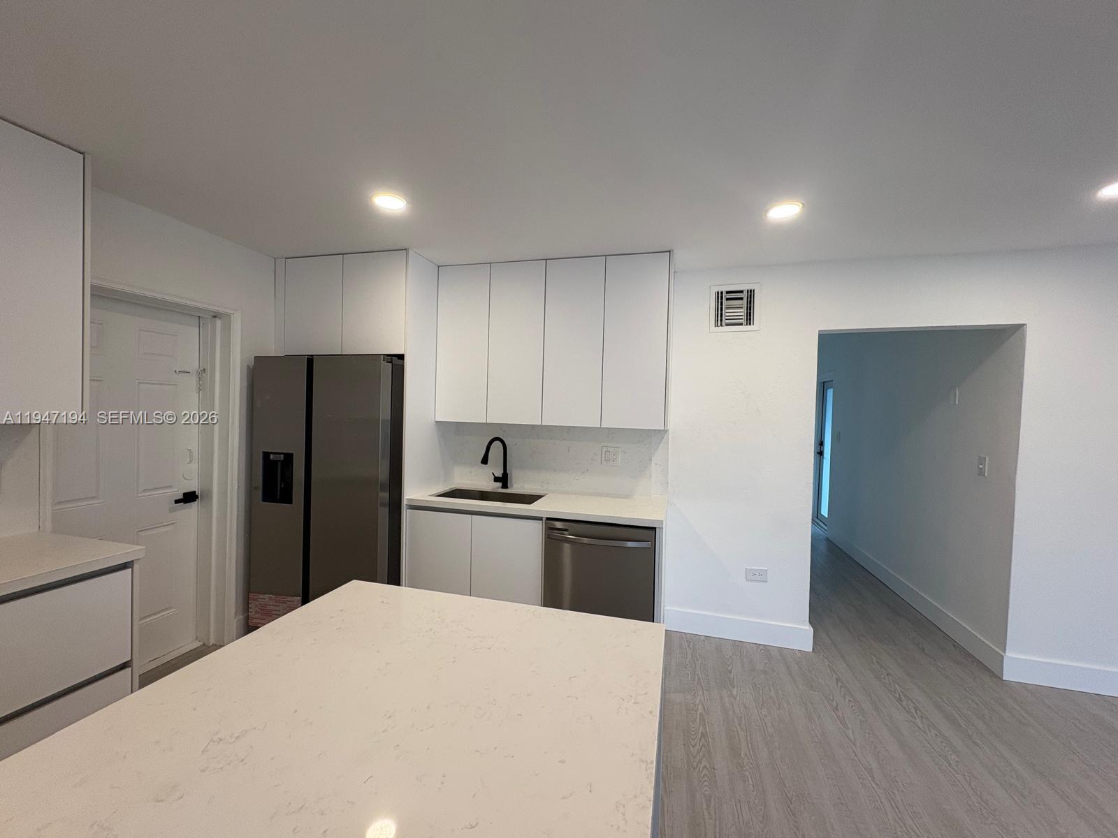 6104 Southwest 33rd Street Miramar, FL 33023 - Photo 6 of 31 a kitchen with a refrigerator a sink and dishwasher