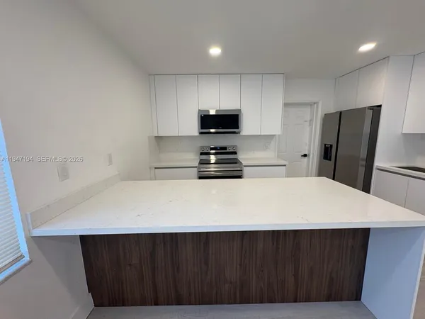 a kitchen with a wooden floor and a refrigerator