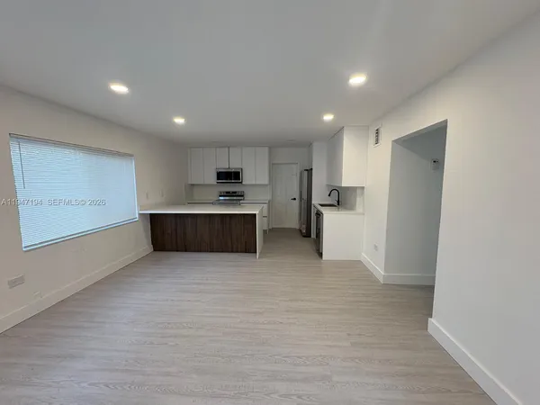 a large kitchen with stainless steel appliances a refrigerator and a stove top oven