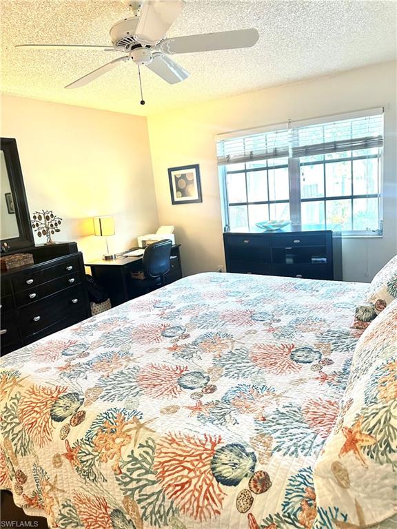 214 Bobolink Way, Unit 214B Naples, FL 34105 - Photo 14 of 15 Bedroom with ceiling fan, multiple windows, and a textured ceiling