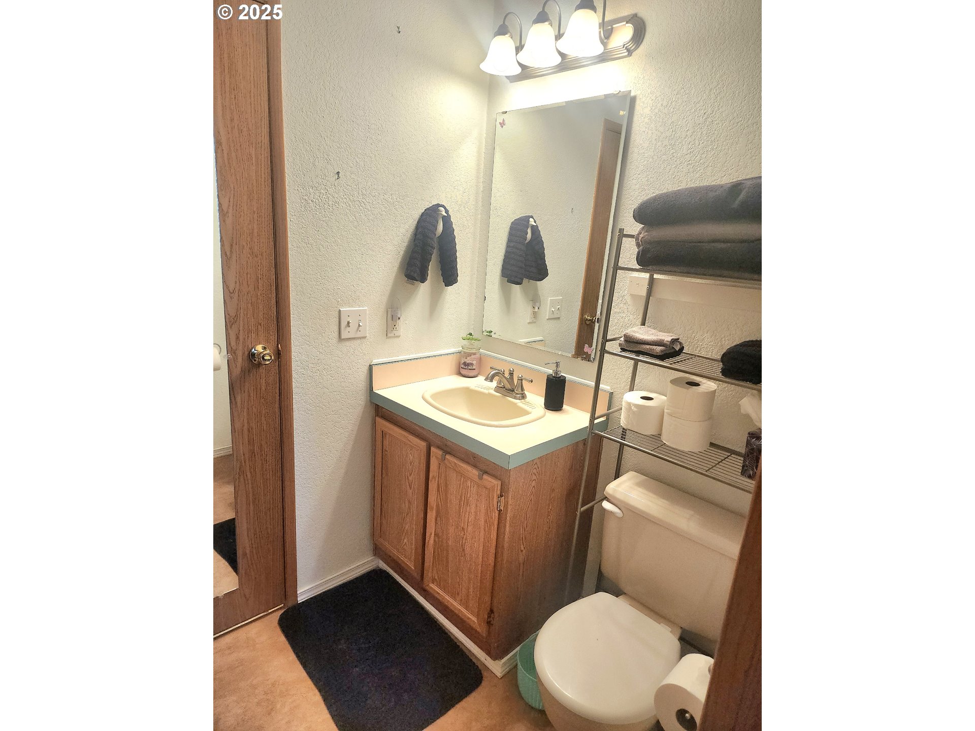 1199 South 58th Street Springfield, OR 97478 - Photo 23 of 30 a bathroom with a toilet sink vanity and mirror