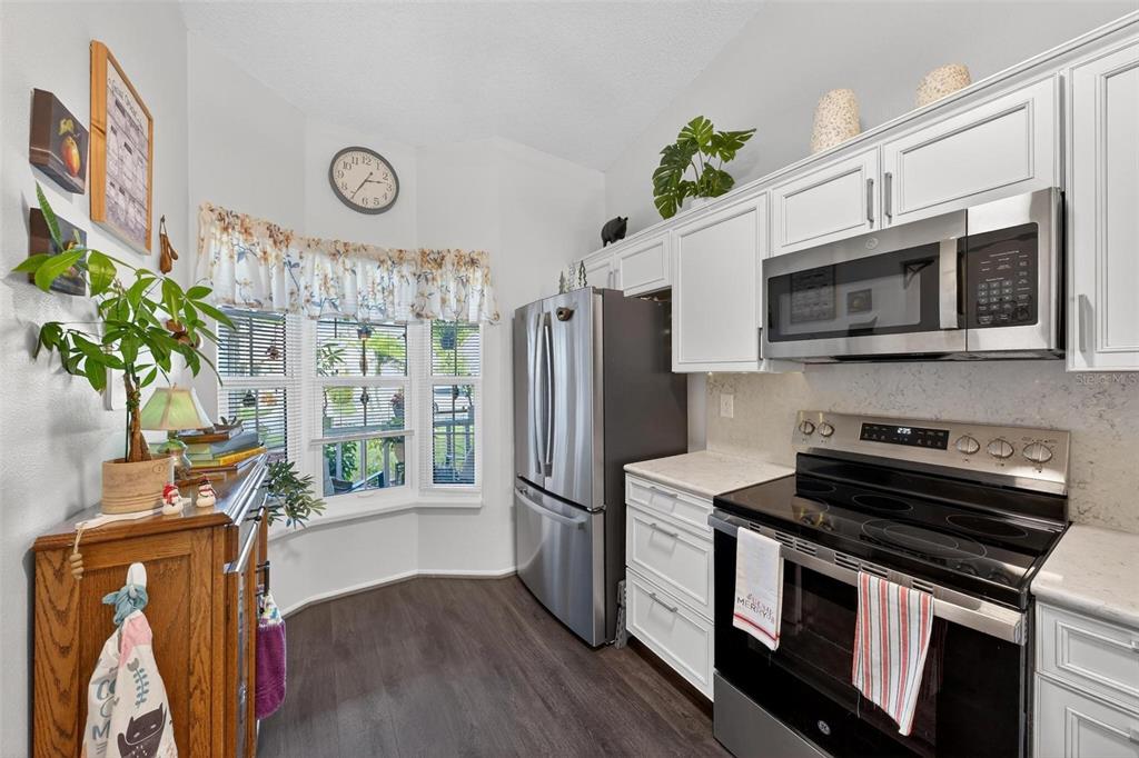 6506 Thicket Trail New Port Richey, FL 34653 - Photo 13 of 71 a kitchen with stainless steel appliances a stove a microwave and a refrigerator
