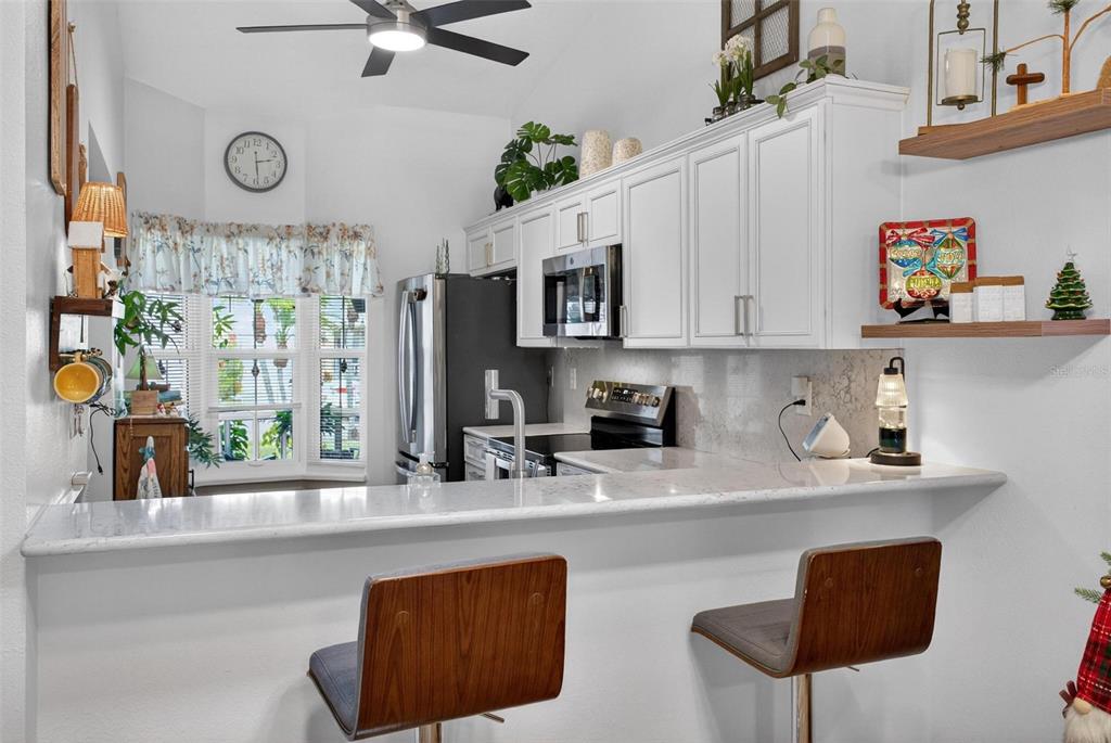 6506 Thicket Trail New Port Richey, FL 34653 - Photo 14 of 71 a kitchen with stainless steel appliances a sink a stove a microwave a refrigerator and cabinets