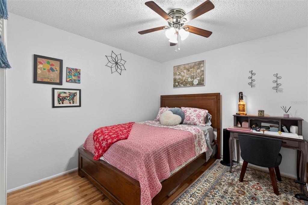 6506 Thicket Trail New Port Richey, FL 34653 - Photo 34 of 71 a bedroom with a bed and a chandelier