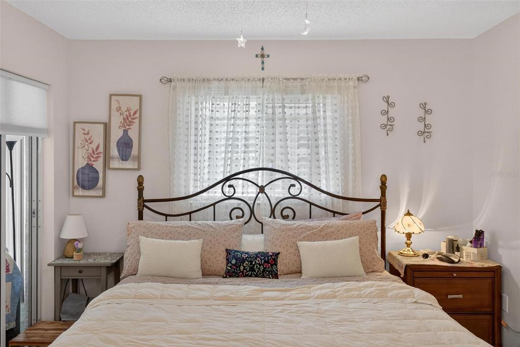 6506 Thicket Trail New Port Richey, FL 34653 - Photo 44 of 71 a bedroom with a bed and a chandelier