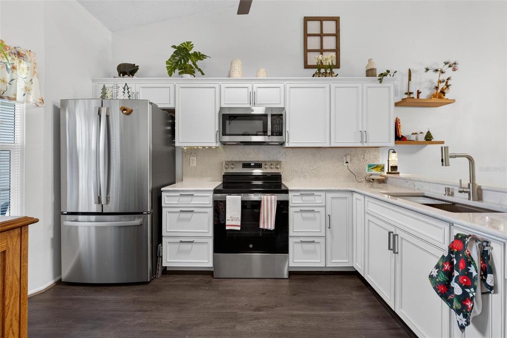 6506 Thicket Trail New Port Richey, FL 34653 - Photo 7 of 71 a kitchen with a refrigerator and a stove top oven