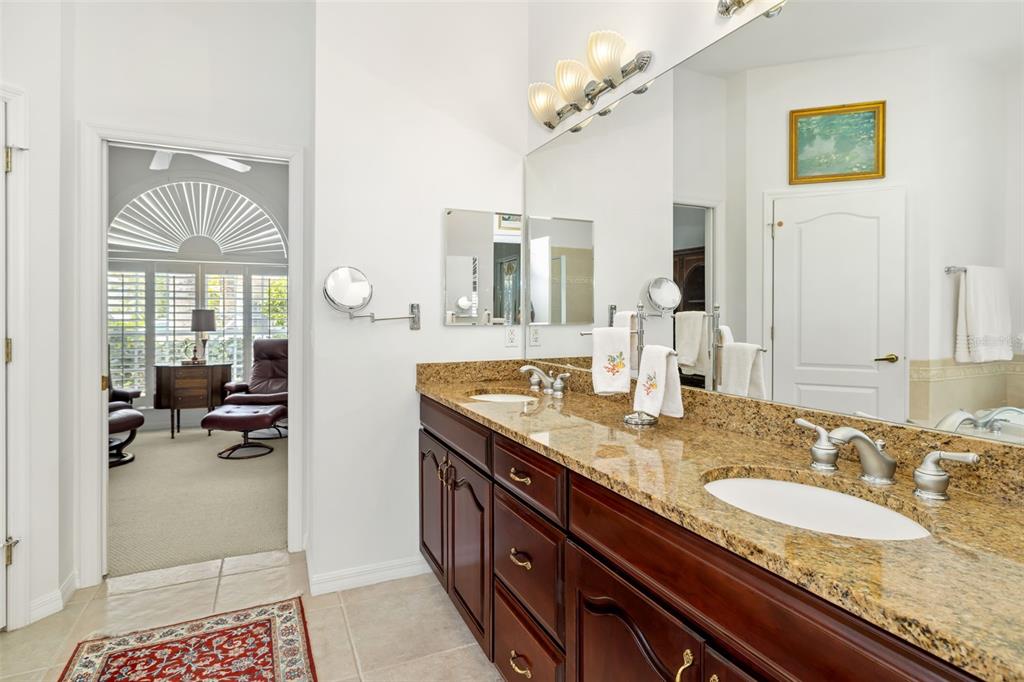 1016 Scherer Way Osprey, FL 34229 - Photo 28 of 76 a en suite bathroom with a granite countertop double vanity and a mirror