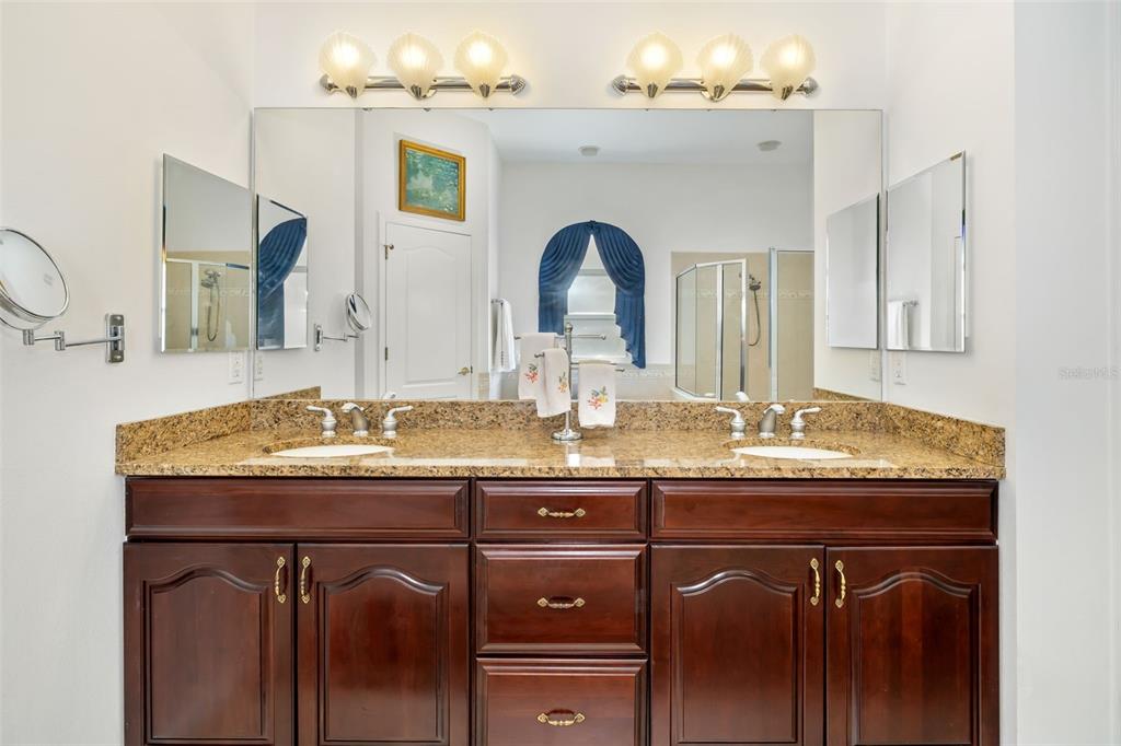 1016 Scherer Way Osprey, FL 34229 - Photo 30 of 76 a bathroom with a granite countertop sink a large mirror and a window