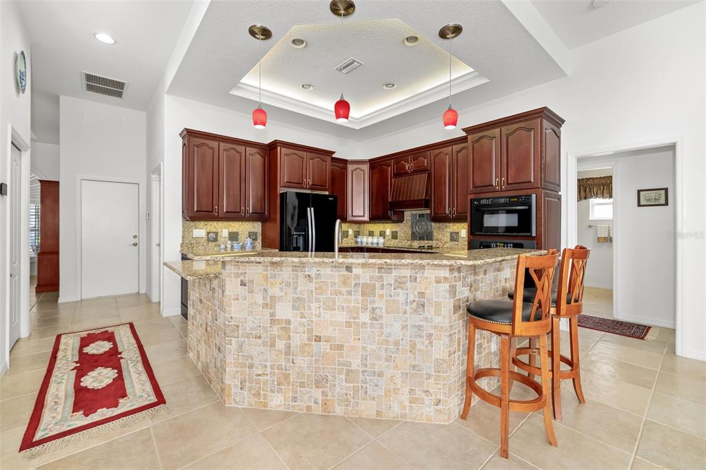1016 Scherer Way Osprey, FL 34229 - Photo 48 of 76 a kitchen with stainless steel appliances kitchen island granite countertop a table chairs in it and a window