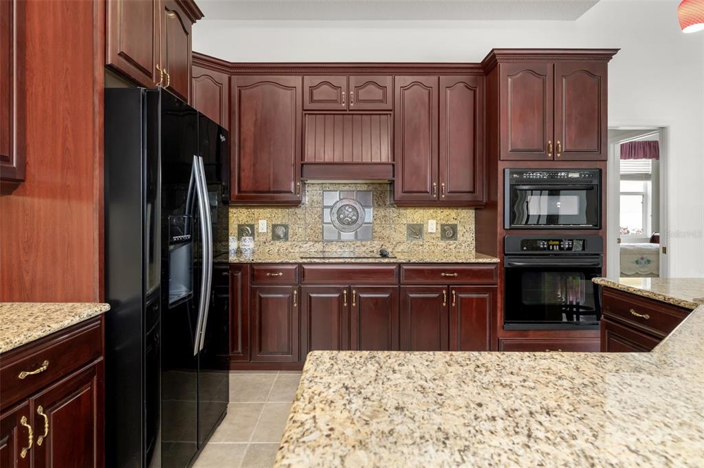 1016 Scherer Way Osprey, FL 34229 - Photo 49 of 76 a kitchen with stainless steel appliances granite countertop a refrigerator stove top oven and large window