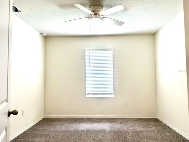 a view of a room with a window and a ceiling fan