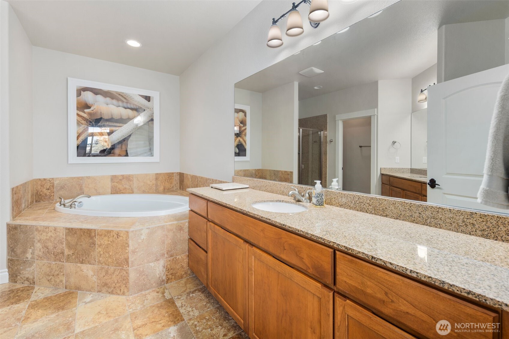 3224 Overlook Loop Ilwaco, WA 98624 - Photo 16 of 38 a bathroom with a granite countertop sink a large mirror a bathtub and a shower