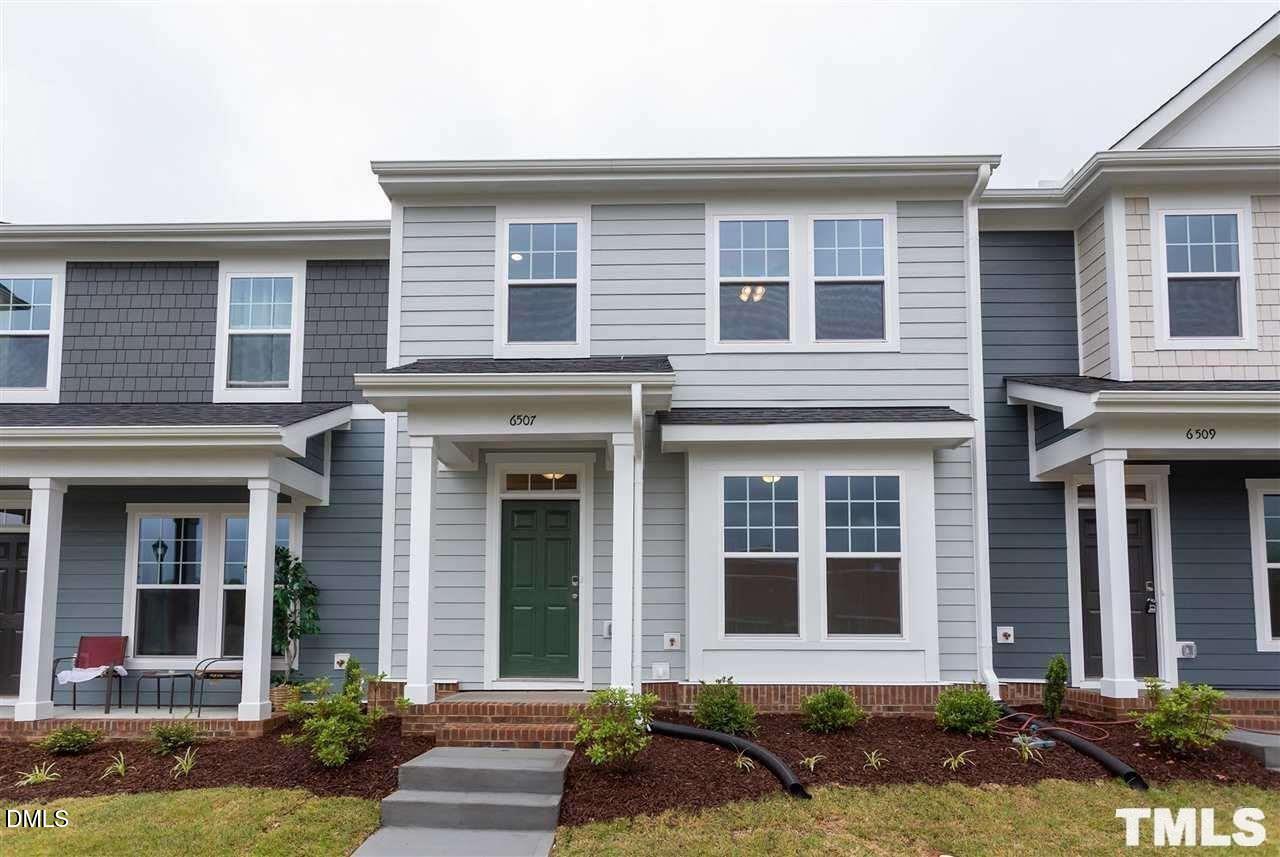 front view of a brick house with a yard
