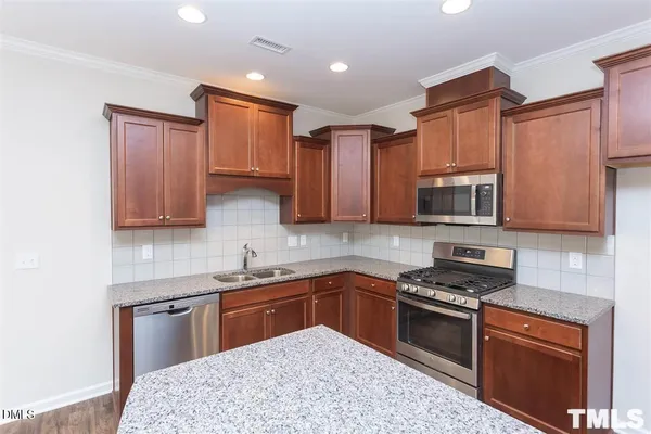 a kitchen with stainless steel appliances granite countertop a sink stove and microwave