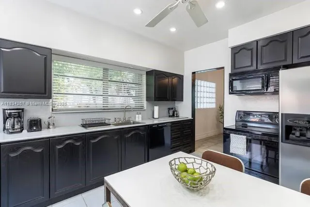 a kitchen with stainless steel appliances kitchen island granite countertop a sink dishwasher stove and microwave with wooden floor