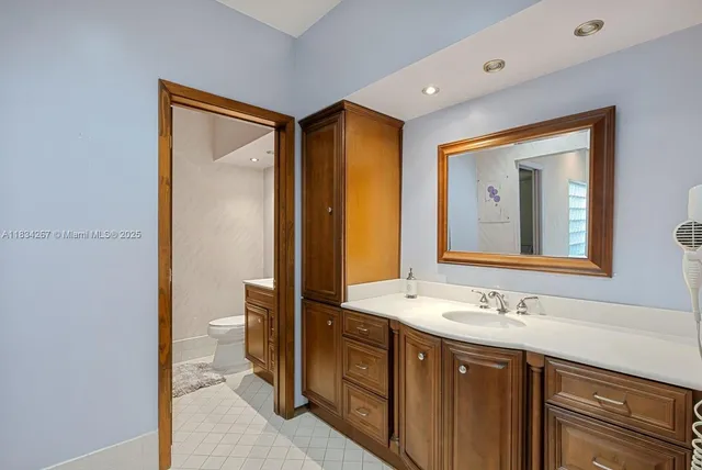 a bathroom with a double vanity sink mirror and toilet