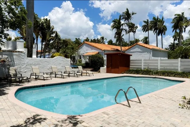 a view of a house with swimming pool and sitting area