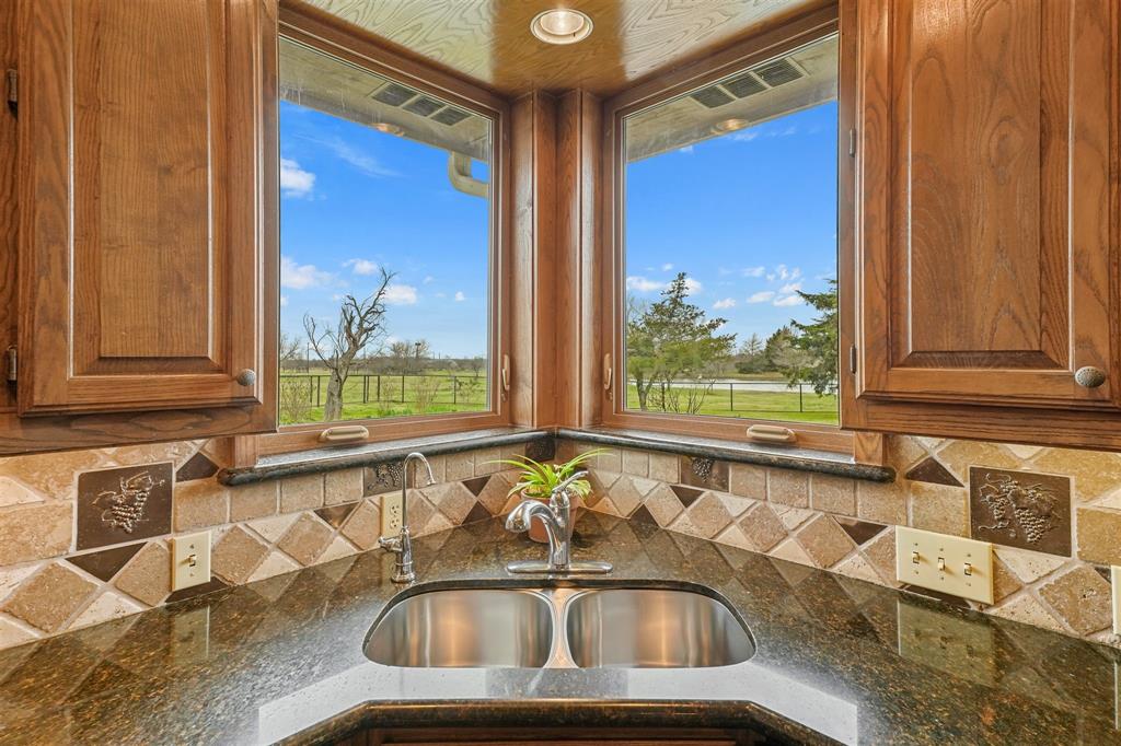 9711 Jim Christal Road Krum, TX 76249 - Photo 17 of 38 a bathroom with a granite countertop tub and a sink
