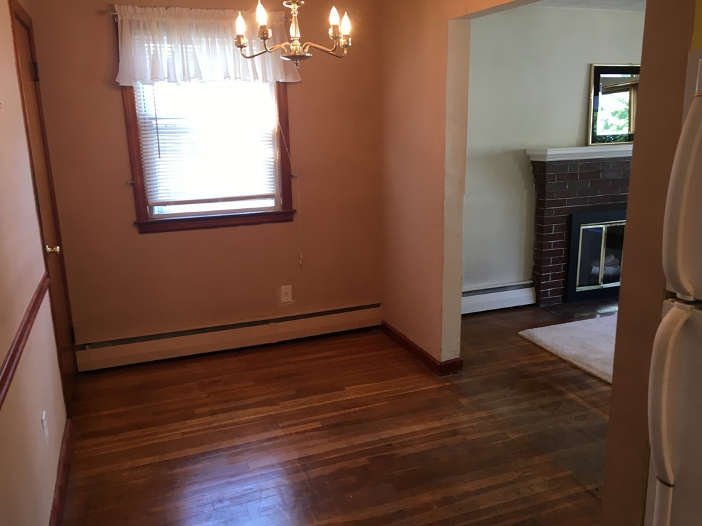 6 Rindone Street Holbrook, MA 02343 - Photo 6 of 18 a room with wooden floor a fireplace and windows