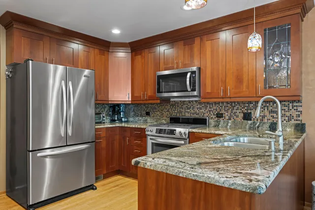 a kitchen with stainless steel appliances granite countertop a refrigerator stove microwave and sink