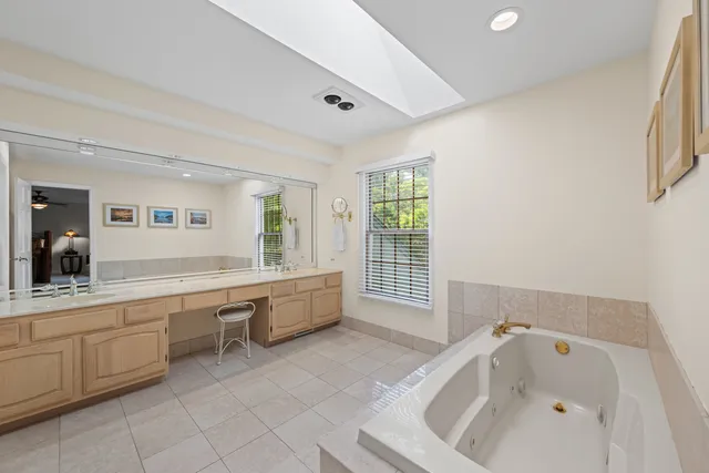 a large white tub sitting in a bathroom next to a sink