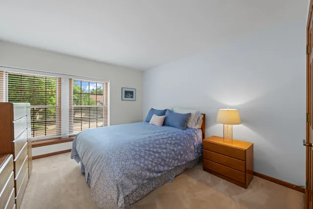 a bedroom with a bed and a lamp next to a window