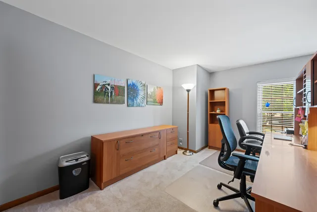 a view of a workspace with furniture and a window