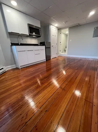 a large kitchen with stainless steel appliances wooden floors and view living room