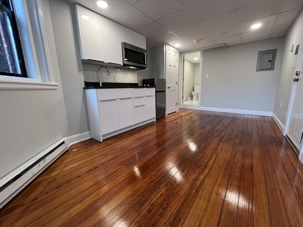 506 Beacon Street, Unit C Boston, MA 02215 - Photo 3 of 4 a kitchen with wooden floors and a sink