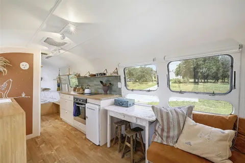a living room with stainless steel appliances furniture a dining table and kitchen view
